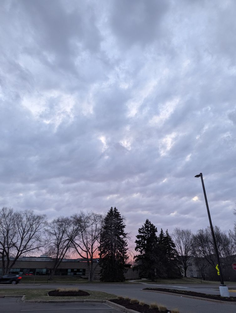 Broken-looking clouds touched with sunset hues.