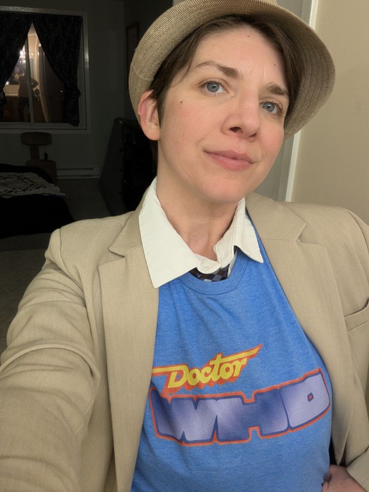 An enby shows off their retro-style Doctor Who t-shirt.