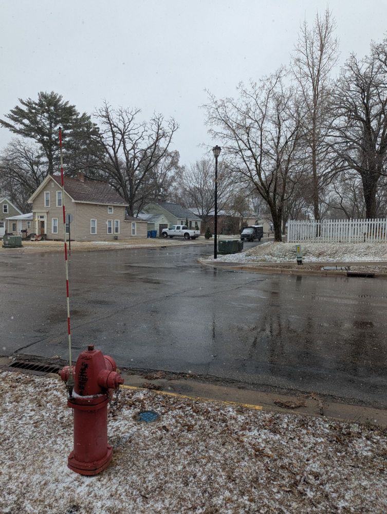 A snowy road and a red fire hydrant.