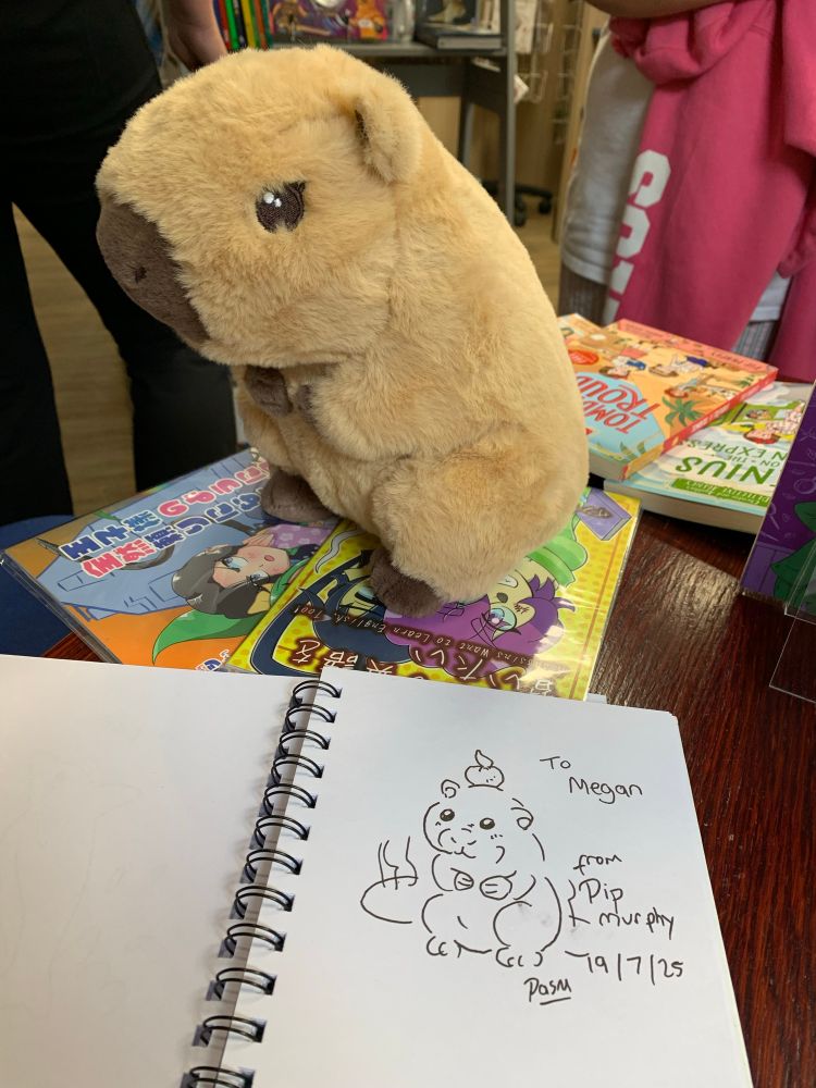 A soft toy capybara along with a simple pen doodle of it.