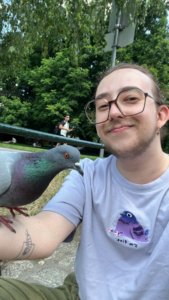 a selfie of me smiling into the camera and a pigeon on my arm