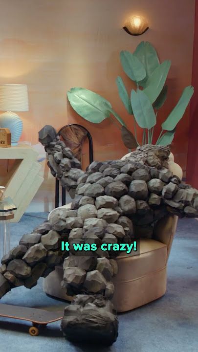 A screenshot of actress Anna Garcia in character as Zeke Aaron McKinley, a 10-year-old boy turned into rocks, on Very Important People, Dropout's improvised talk show. Zeke is leaning back casually and talking about how something was "crazy" as the subtitles say.
