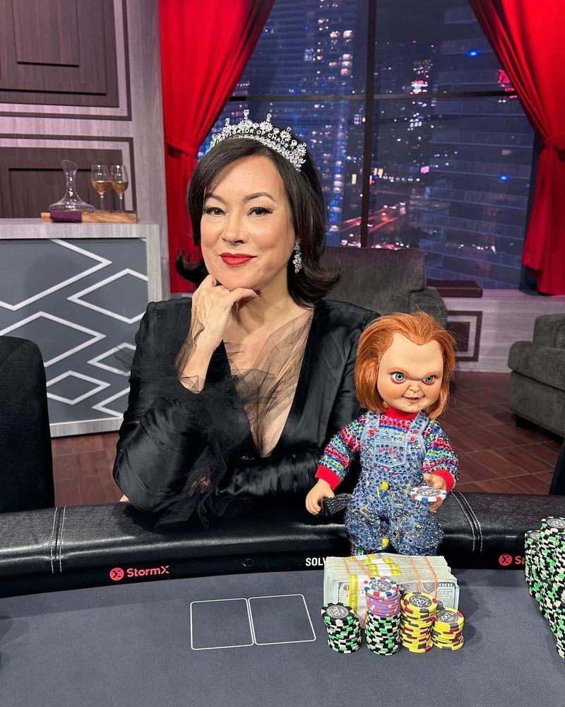 Jennifer Tilly and Chucky sit at a poker table