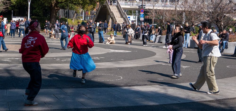 A group of 1 man and 3 women dancing to 50’s rock’n’roll at the entrance to Yoyogi Park. 
