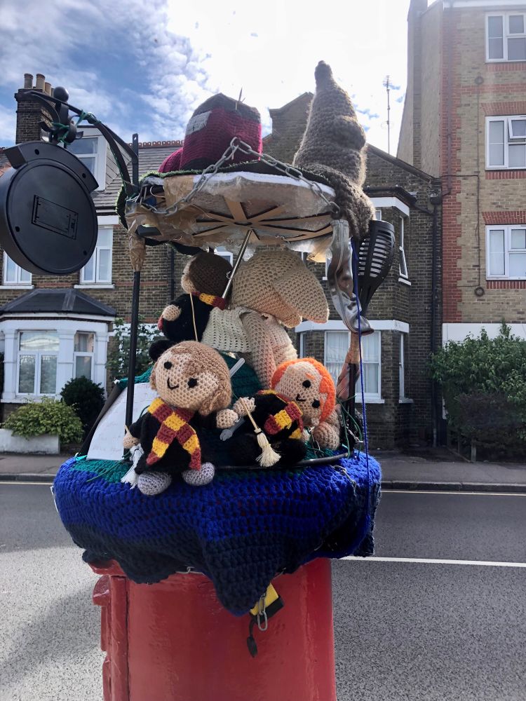 Postbox with postbox topper showing another view of characters from Harry Potter and the sorting hat