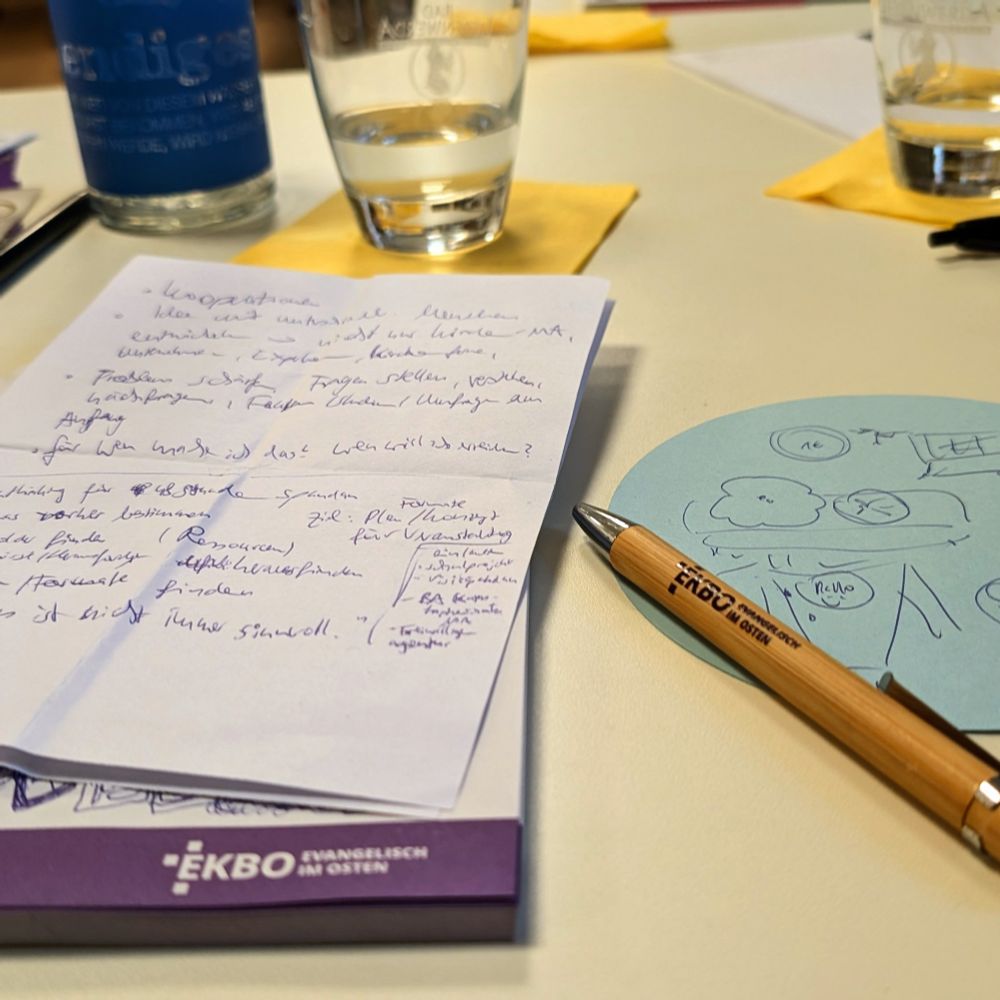 Block mit Notizen, Stift, Kritzeleien und Wassergläser 