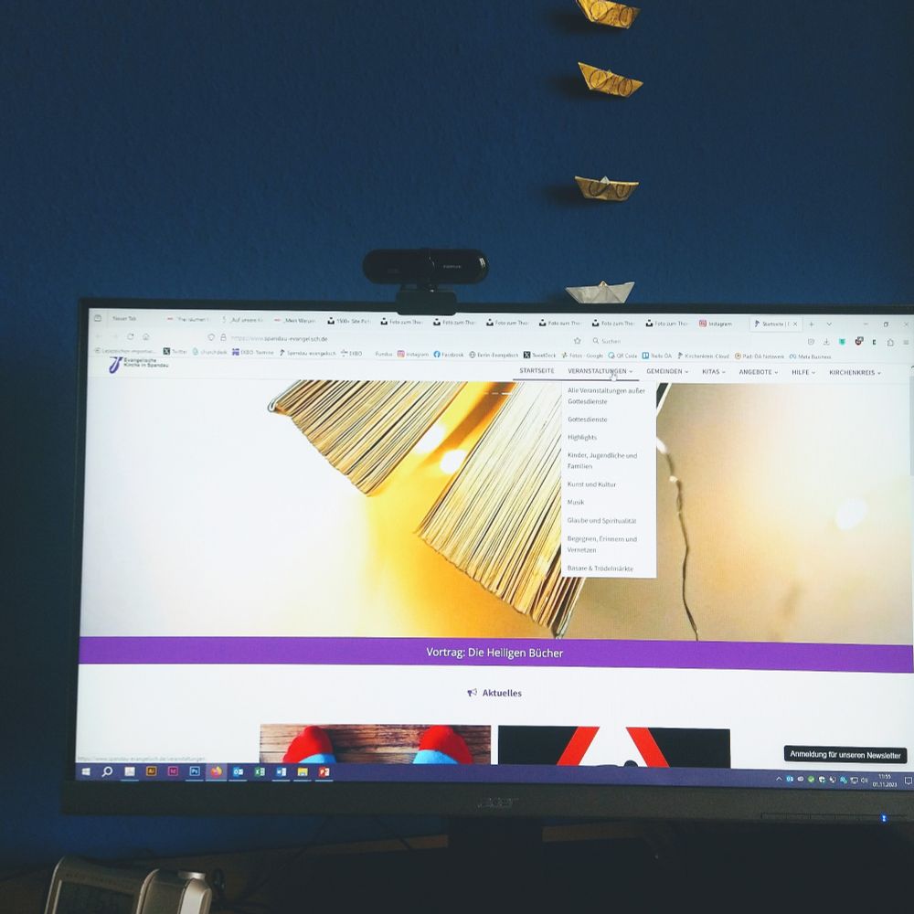 Monitor zeigt Kirchenkreis-Website mit Buch und Lichterkette. 