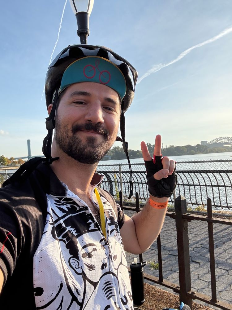 Gay guy in bike gear posing with the sunrise 