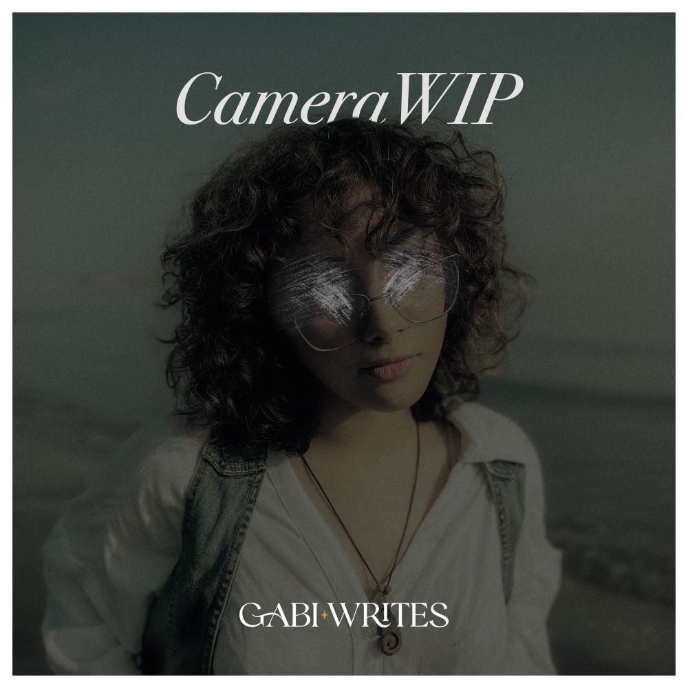 A girl with curly hair and glasses stares at the camera with scratched out eyes. The ocean is behind her. White text reads CameraWIP.
