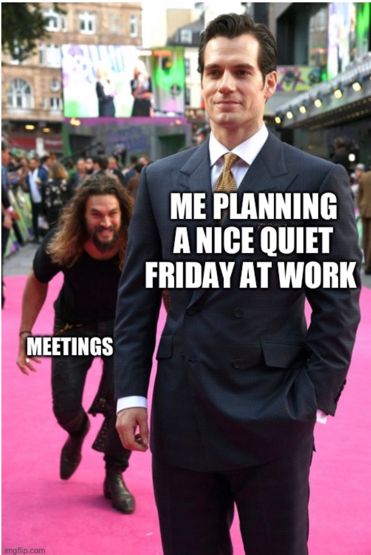 An unsuspecting Henry Cavill stands on a red carpet in a suit. He’s labeled “me planning a nice quiet Friday at work.” Jason momoa is sneaking up behind him. He’s labeled “MEETINGS.”