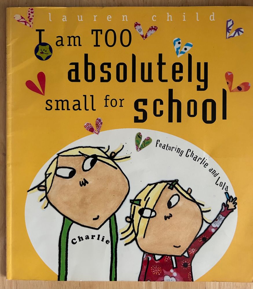 A children’s picture book I am too absolutely small for school by Lauren Child. Mostly yellow cover, title in black, picture of brother and sister Charlie and Lola looking at each other.
