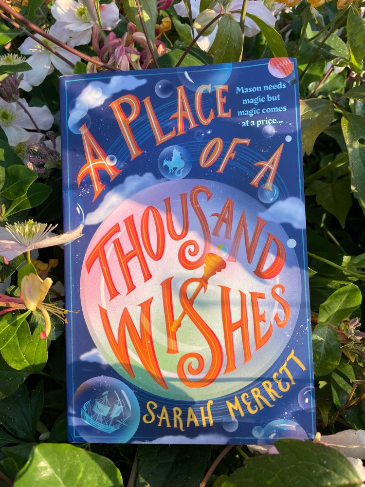 Paperback book A Place of A Thousand Wishes by Sarah Merrett features a large crystal ball and title in orange font.