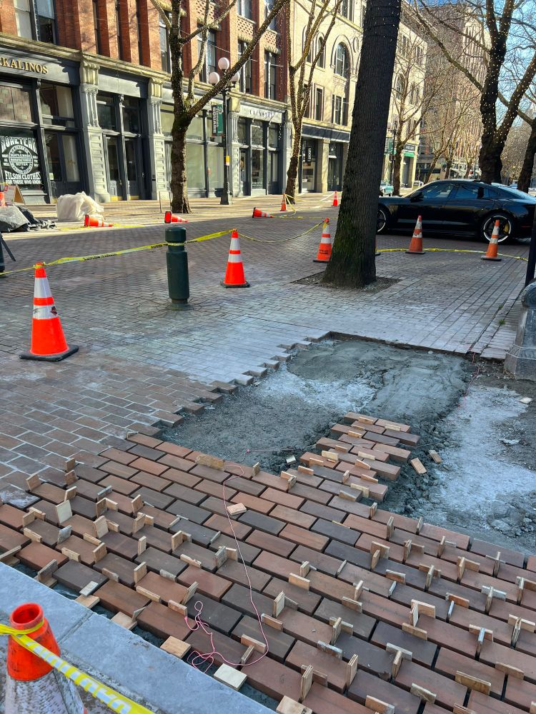 A brick street is being repaired, new bricks being placed. In the pioneer square neighborhood in Seattle. 
