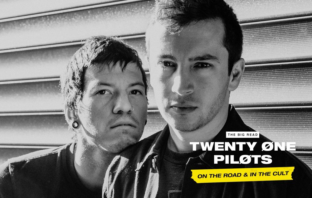 Tyler Joseph looks VERY SERIOUS and Josh Dun looks like a sad puppy, resting his chin on Tyler’s shoulder.
