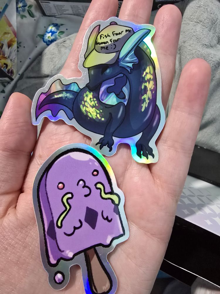 Stickers of a swalot as an ice cream and a creature wearing a hat that says "fish fear me women fear me :)"