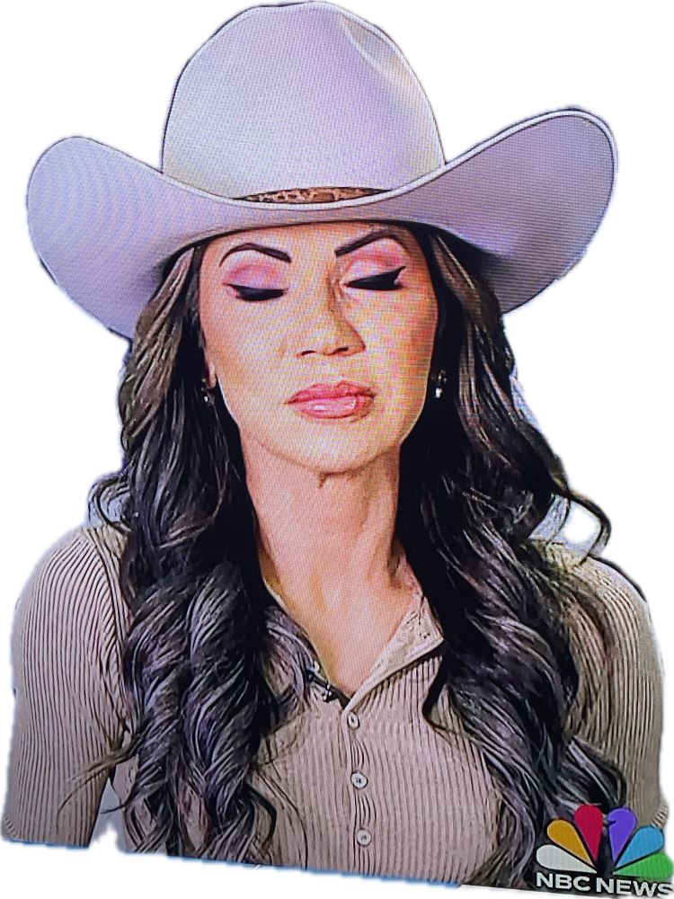 Photo of Kristi Noem on Meet The Press. She is wearing a light gray Stetson cowboy hat and a tan corduroy button up shirt. Also too much makeup and Botox. Her eyes are shut. Her expression looks like disdain or pain.