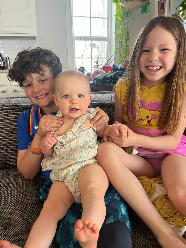 Picture of three siblings smiling together