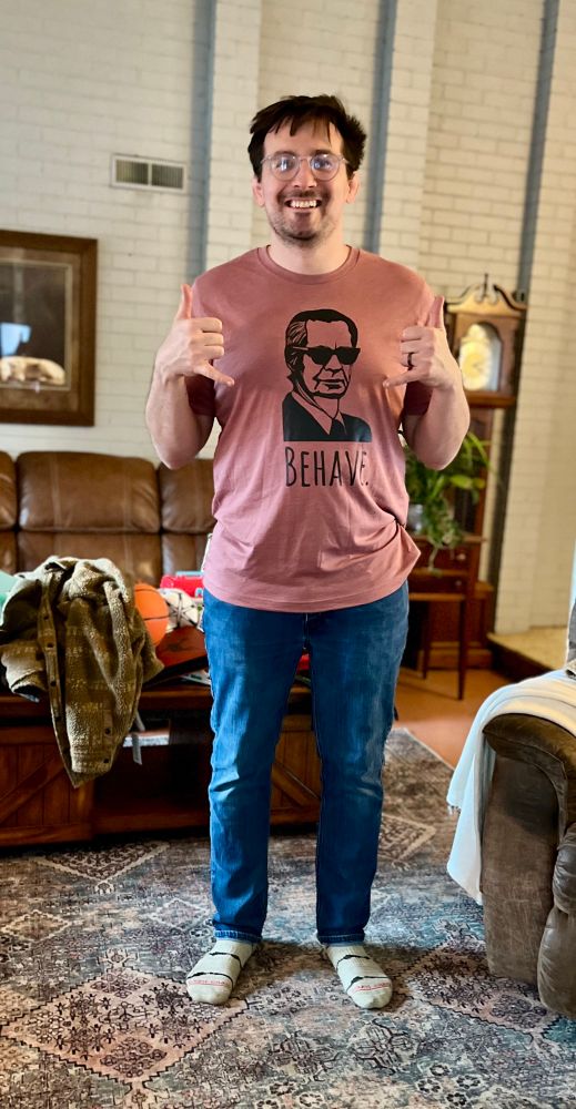 Me standing in a shirt that say Behave and has an outline of BF Skinner’s head. 
