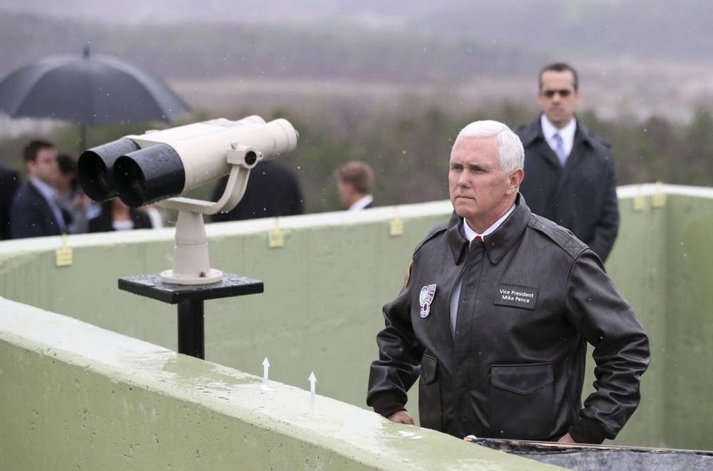 Mike Pence wearing a leather jacket looking at the Korean DMZ. He’s posturing with his arms bent like a toddler pretending to be tough 