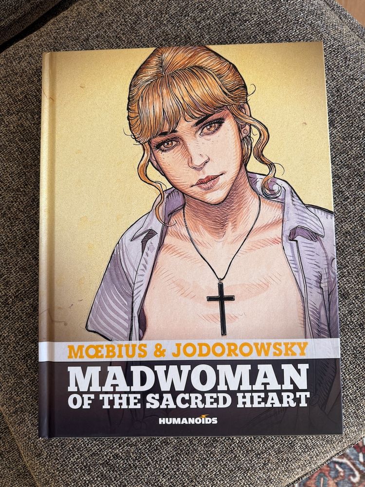 Photo of the large size graphic novel: Madwoman of the Sacred Heart. Art by Jean Giraud Moebius, story by Alejandro Jodorowsky. Views of several interior pages.
