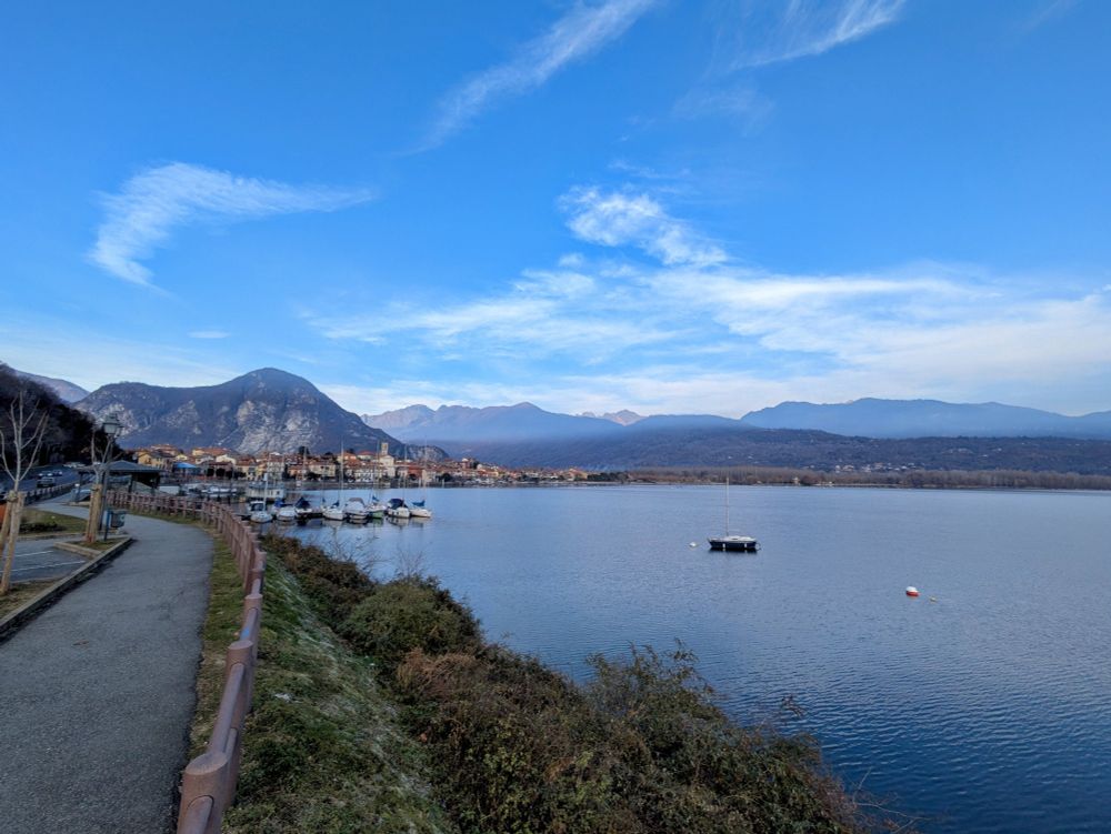 View over the Lago Maggiore, under blue sky, with the Italian Alps in the background. 