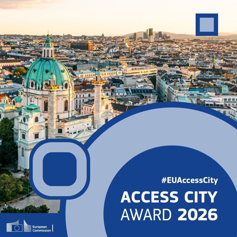 A panoramic view of Vienna, with a beautiful white cathedral with green roofs at the forefront. Above it a blue banner with abstract shapes saying Access City Awards 2026