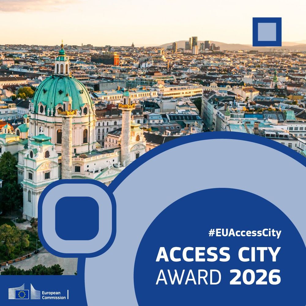 A panoramic view of Vienna, with a beautiful white cathedral with green roofs at the forefront. Above it a blue banner with abstract shapes saying Access City Awards 2026