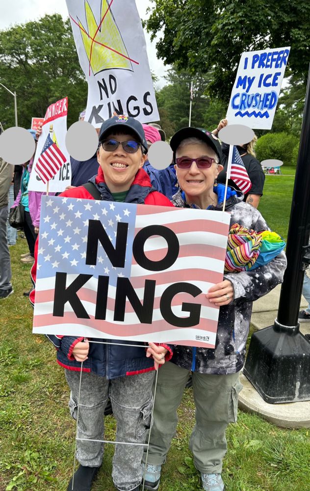 Us holding a sign reading “NO KING”