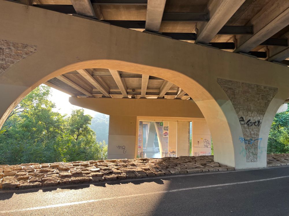 Looking east under the Lake-Marshall bridge. In view are the bridge pilings with graffiti and haze in the air. 