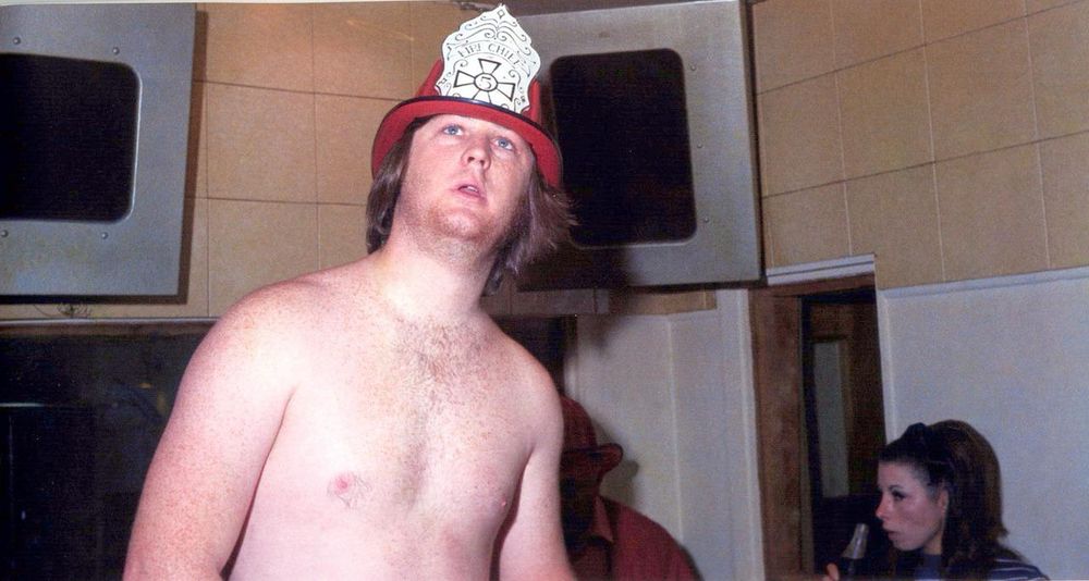 Brian Wilson, very high, shirtless with a fire-hat on his head in the studio