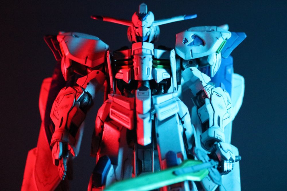 Custom painted Full Mechanics Gundam Bael from Iron Blooded Orphans, starkly lit with red light from the left, and blue light from the right.