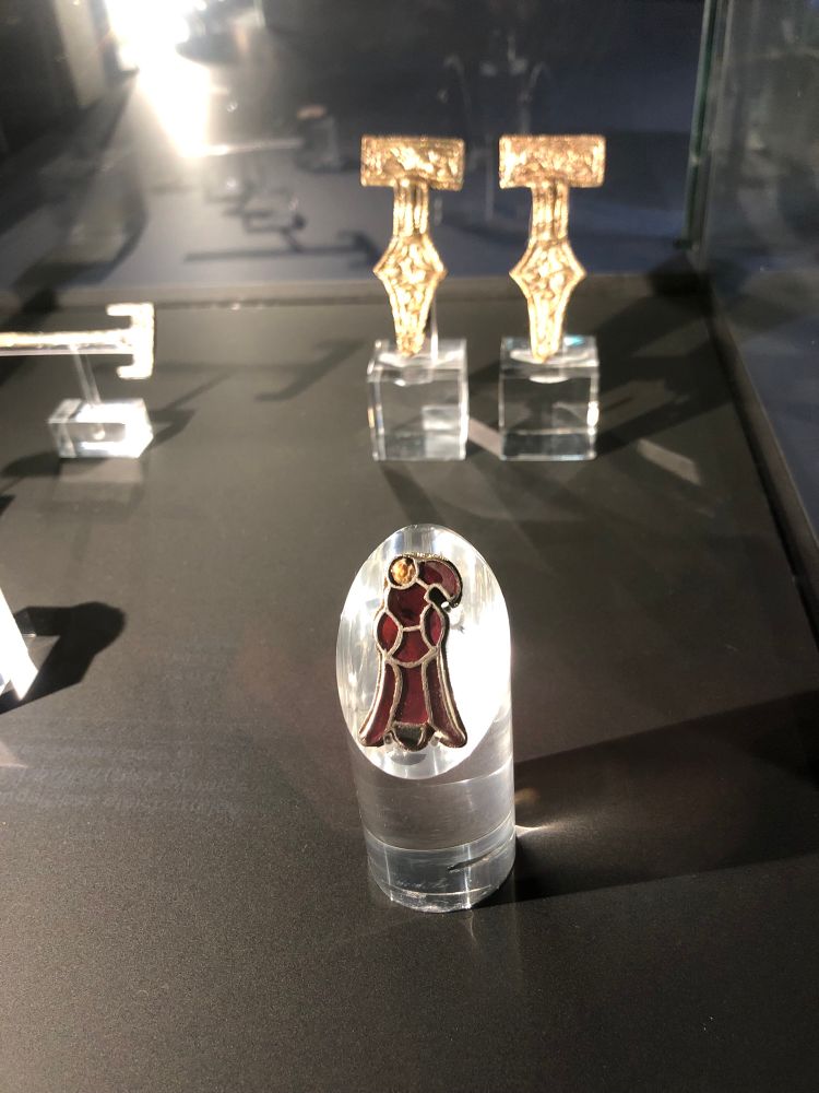 A bird shaped golden and garnet brooch
