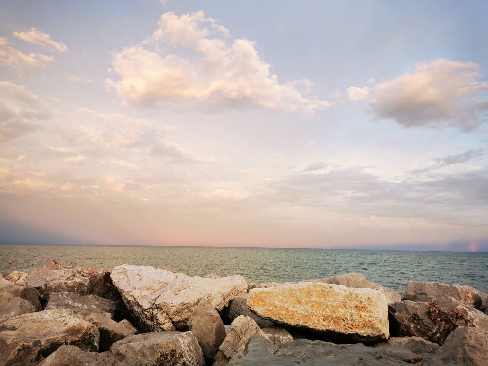 Rocks, behind them sea and pastel colors sky