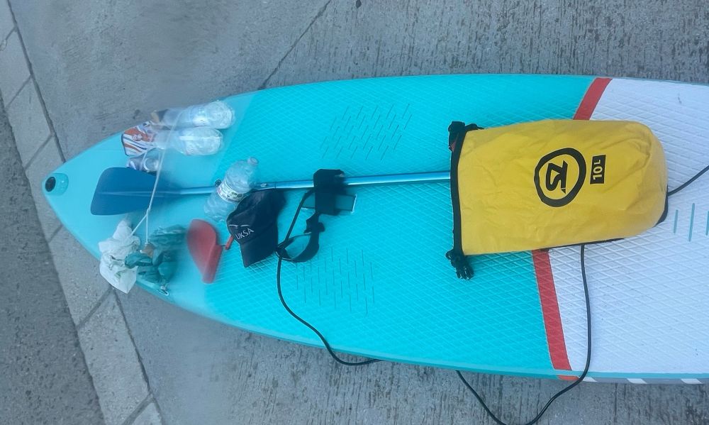 Blick auf das SUP mit einigem Equipment und dem gesammelten Müll