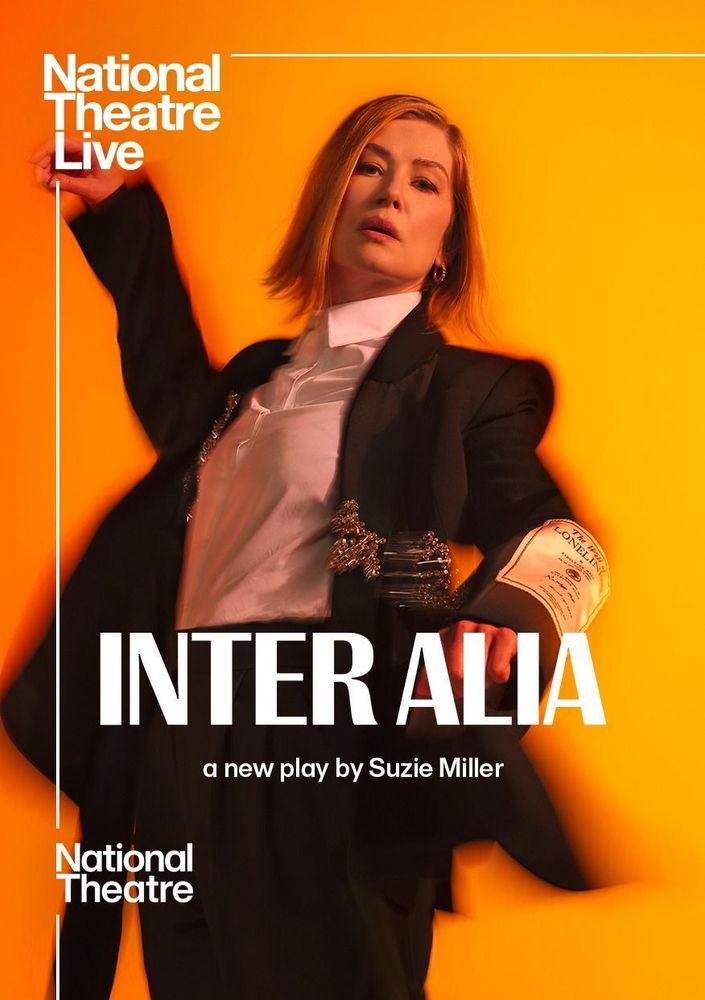 on an orange and yellow background, rosamund pike dressed in a suit with orate braoches attached to it dances.

White text reads national thetare live Inter Alia a new play by suzy miller national theatre
