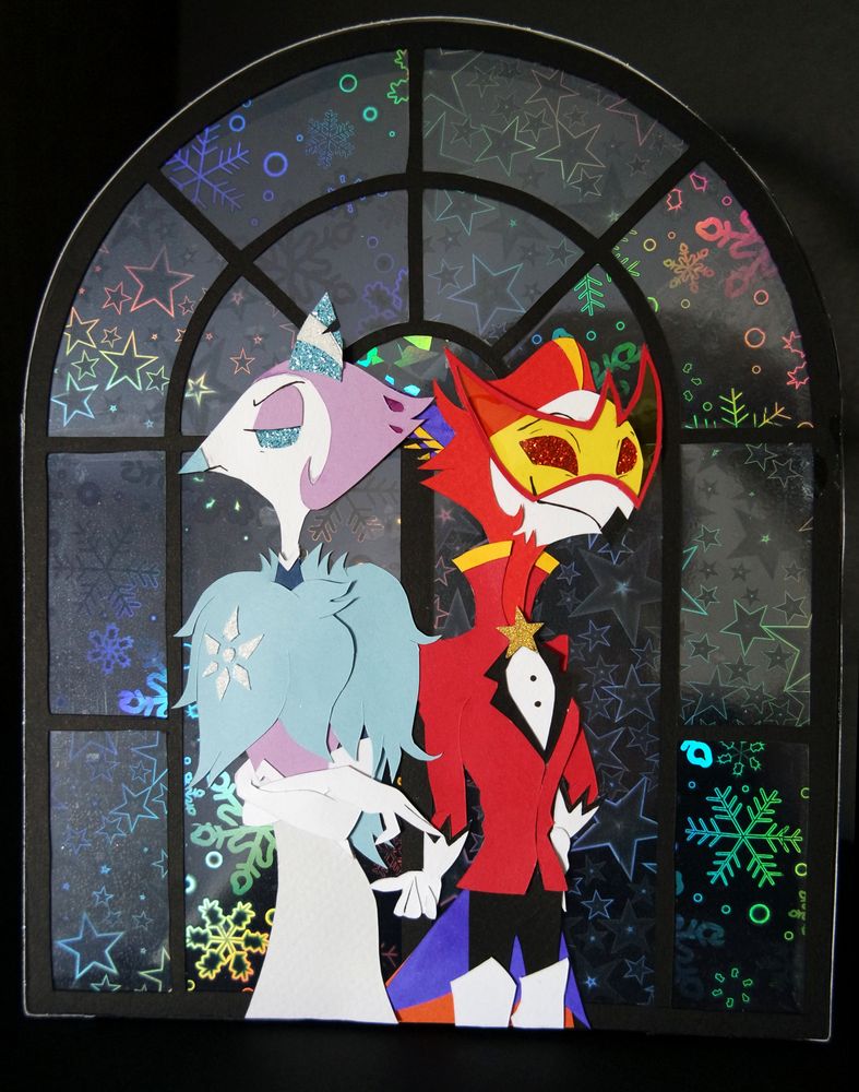Papercraft standee of Andrealphus and Vassago, back to back, Vassago stretches his hand out to Andre, who acts uninterested but is sneakily reaching out as well. The background is an art deco style window with holographic patterns of stars and snowflakes