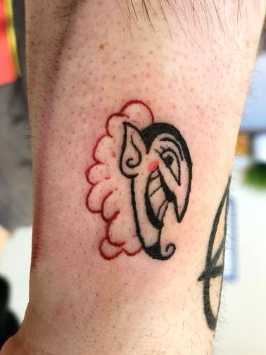 a red, pink, and black tattoo of the character HIM from The Powerpuff Girls, on pale flesh