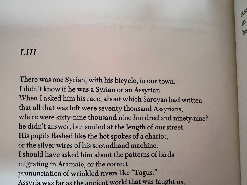 Photo of a page from Walcott’s Collected poems, in this case from an 84 book titled Midsummer. 

Text:

LIII
There was one Syrian, with his bicycle, in our town.
I didn't know if he was a Syrian or an Assyrian.
When I asked him his race, about which Saroyan had written that all that was left were seventy thousand Assyrians, where were sixty-nine thousand nine hundred and ninety-nine? he didn't answer, but smiled at the length of our street.
His pupils flashed like the hot spokes of a chariot, or the silver wires of his secondhand machine.
I should have asked him about the patterns of birds migrating in Aramaic, or the correct pronunciation of wrinkled rivers like "Tagus." Assvria was far as the ancient world that was taught us,