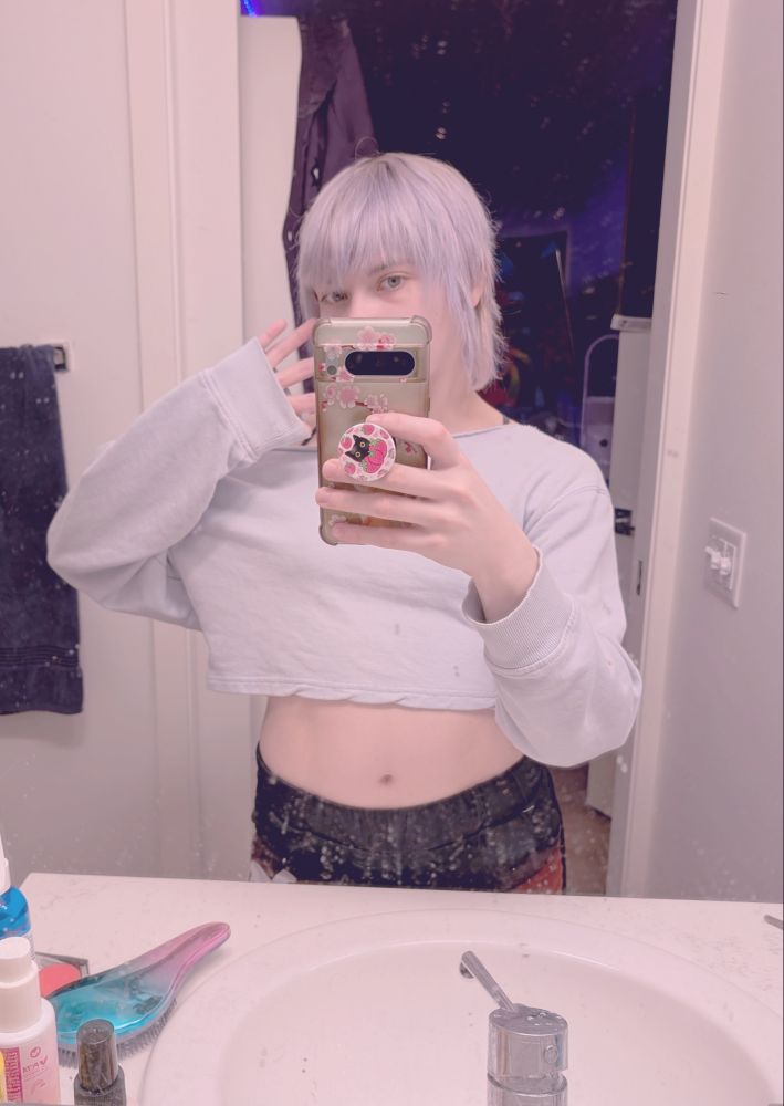 bathroom mirror selfie of me, i have a light blue sweatshirt on, black and orange shorts, and short silver hair. 