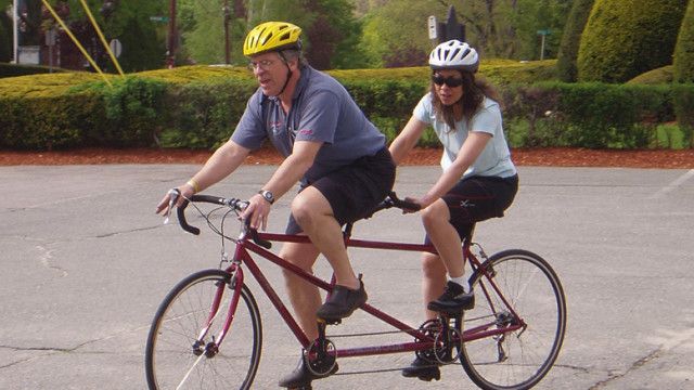 Tandem bike, girl on the back.