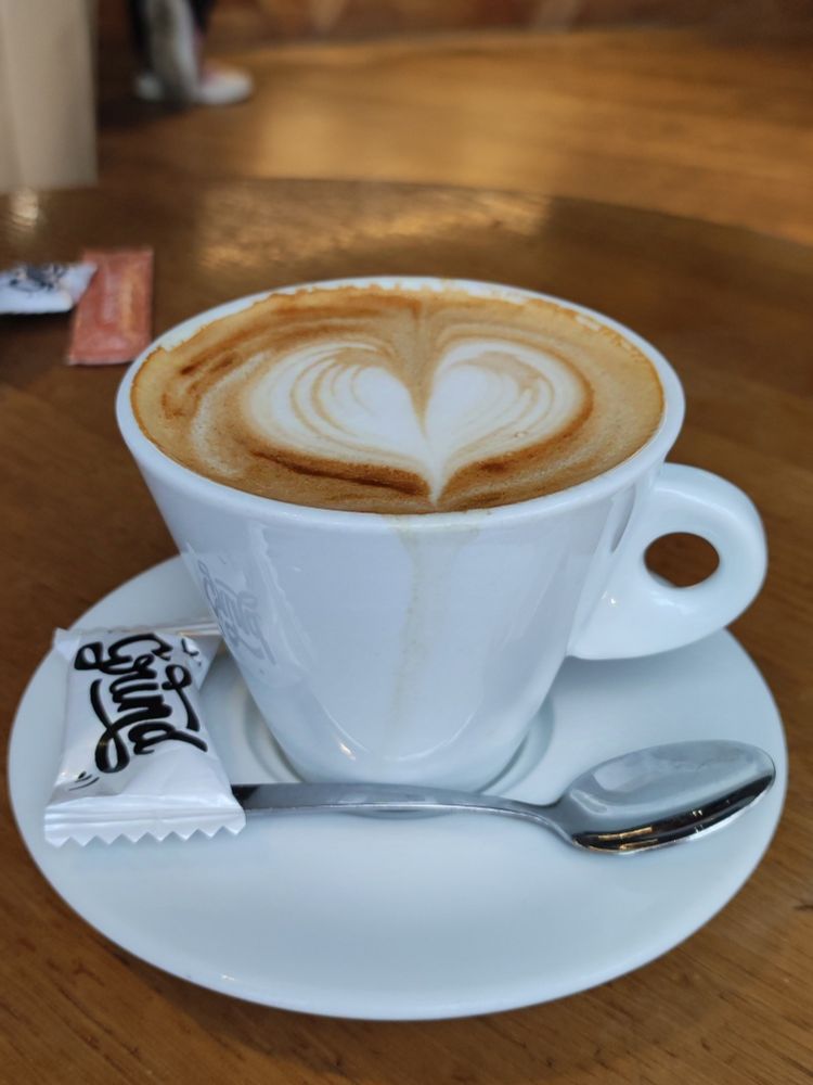 Une tasse de cappuccino avec un joli cœur dessiné avec le lait à la surface du café