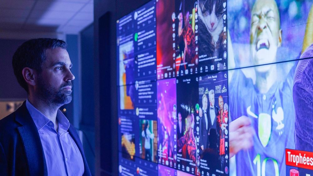Xavier Robic, devant un mur d'écrans