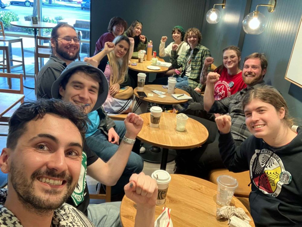 DSA members sitting inside of the Gateway sb with drinks, fists held up in solidarity 