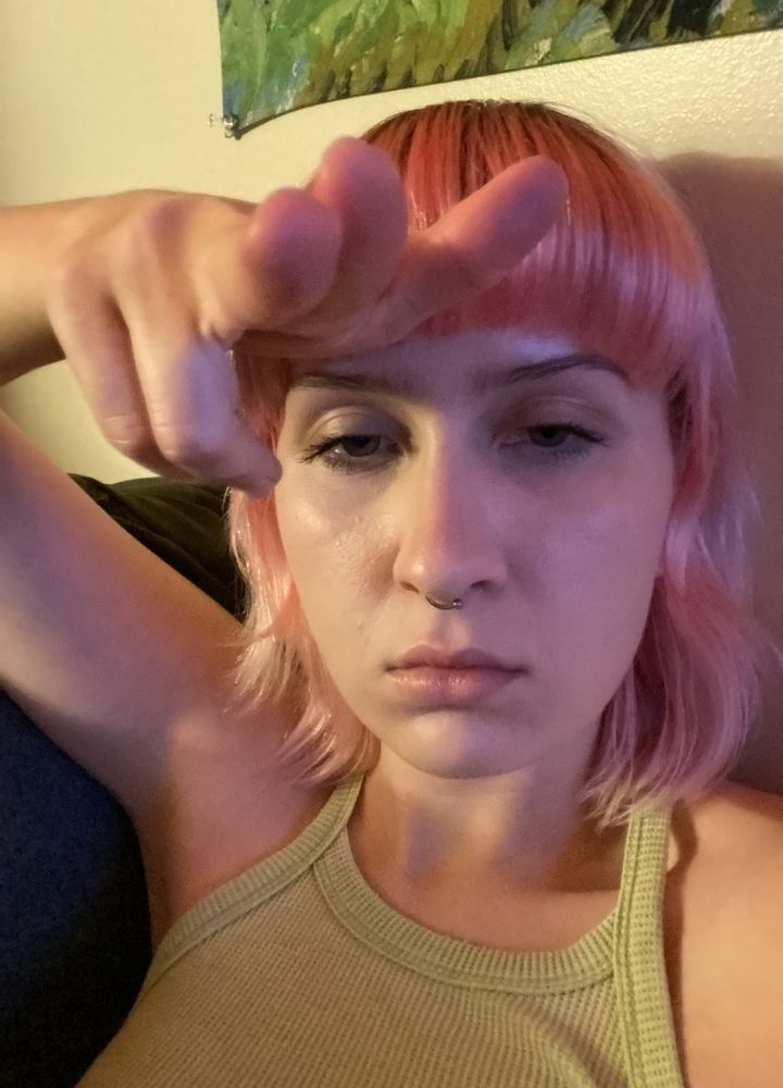 me sitting on my futon in my room waiting for my girlfriend making a finger gun at the camera