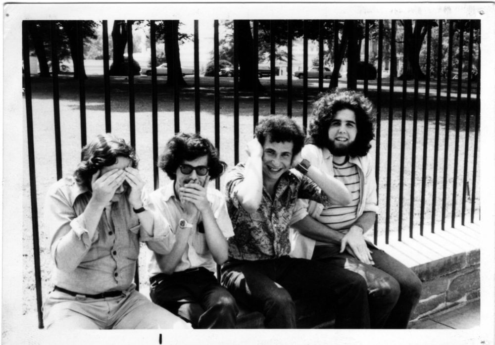 Four scruffy teens sitting on a ledge with their backs to a fence. Each uses their hands to cover a body part. The first is covering his eyes, the second, his mouth, the third, his ears, the fourth, his lap, doing a see no evil, speak no evil, hear no evil, touch no evil motif. Though you can't make it out through the fence, the White House is on the other side.