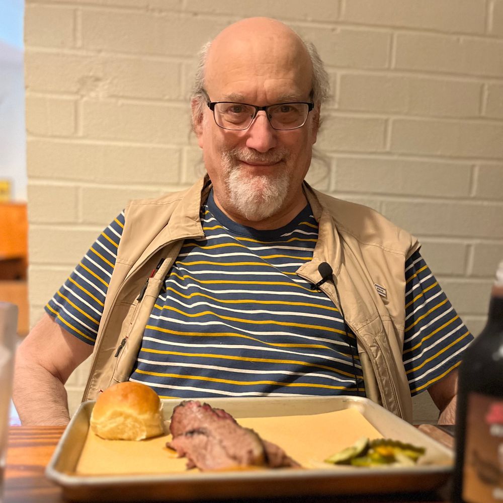 Mike across the table from me viewed over his tray of brisket.