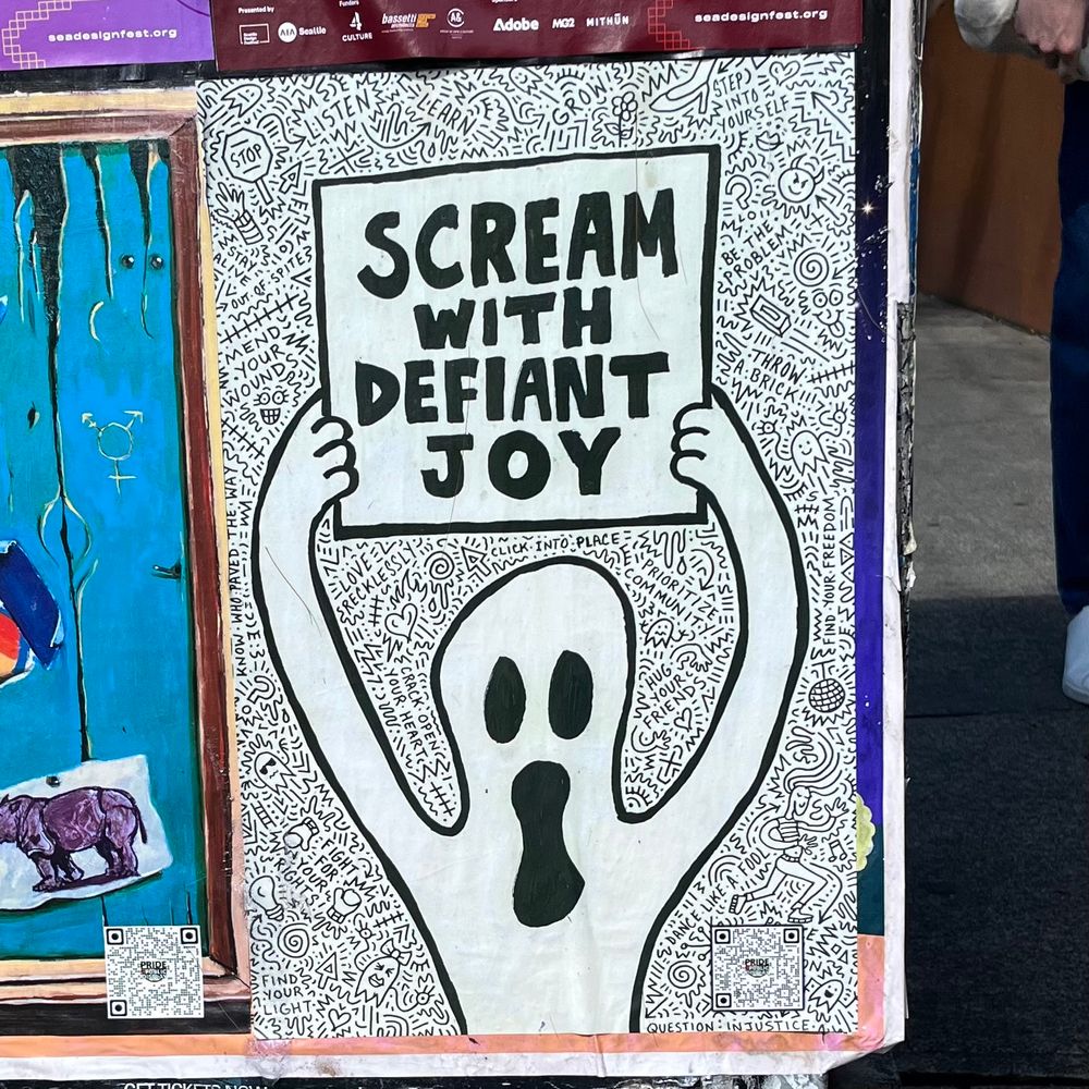 A Keith Haring-esque ghostly figure holding up a sign which reads SCREAM WITH DEFIANT JOY.