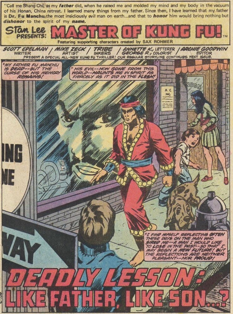 The splash page for a Shang-Chi story written by me and drawn by Mike Zeck. It depicts our hero walking down a NYC street, with a giant face of Fu Manchu floating ghostly in a shop window. The three captions read:

"My father Fu Manchu is dead -- but the curse of his memory remains!"

"His evil -- now gone from this world -- haunts me in spirit as fiercely as it did in the flesh!"

"I find myself reflecting often these days on the man who sired me -- a man I would like to lose in the past -- so that I may begin a new future! But the reflections are neither pleasant -- nor proud!"

TITLE: Deadly Lesson: Like Father, Like Son ... ?