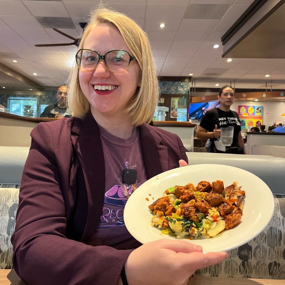 Bonnie across the table from me displaying her Spicy Vegan breakfast bowl.