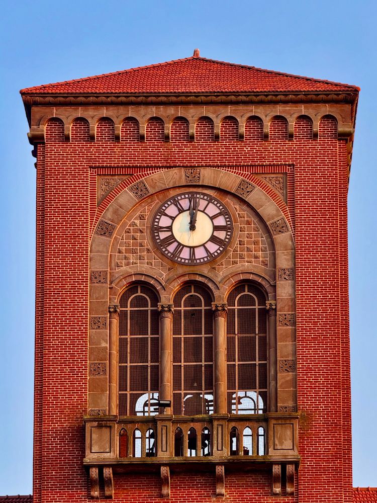 Red brick Clock tower featuring lots of little arches 
